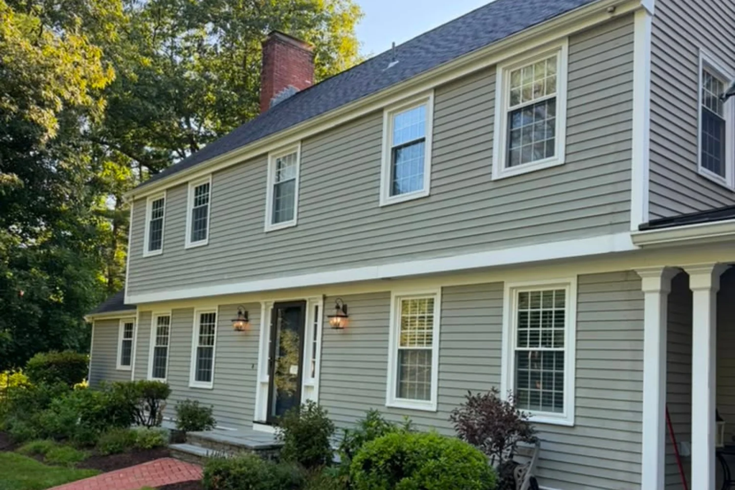 Front exterior of a two-story home with sage green siding and white-trimmed windows
