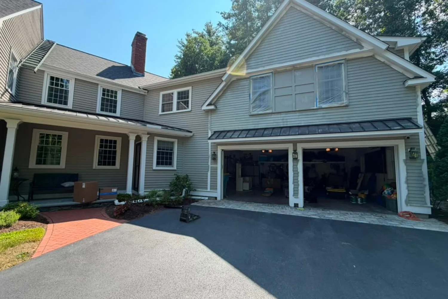 Front exterior of a home with two-car garage and covered porch during exterior work